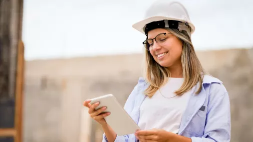 Eine Architektin mit Tablet auf einer Baustelle