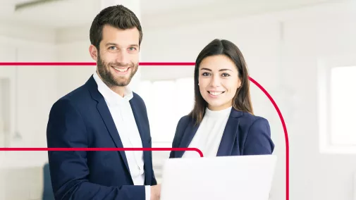 Business Mann und Frau nebeneinander vor Laptop