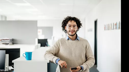 Man with smartphone standing in the office