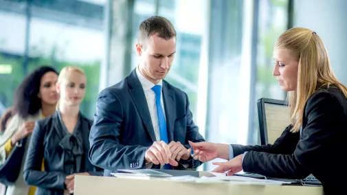 Man signs a document at a counter